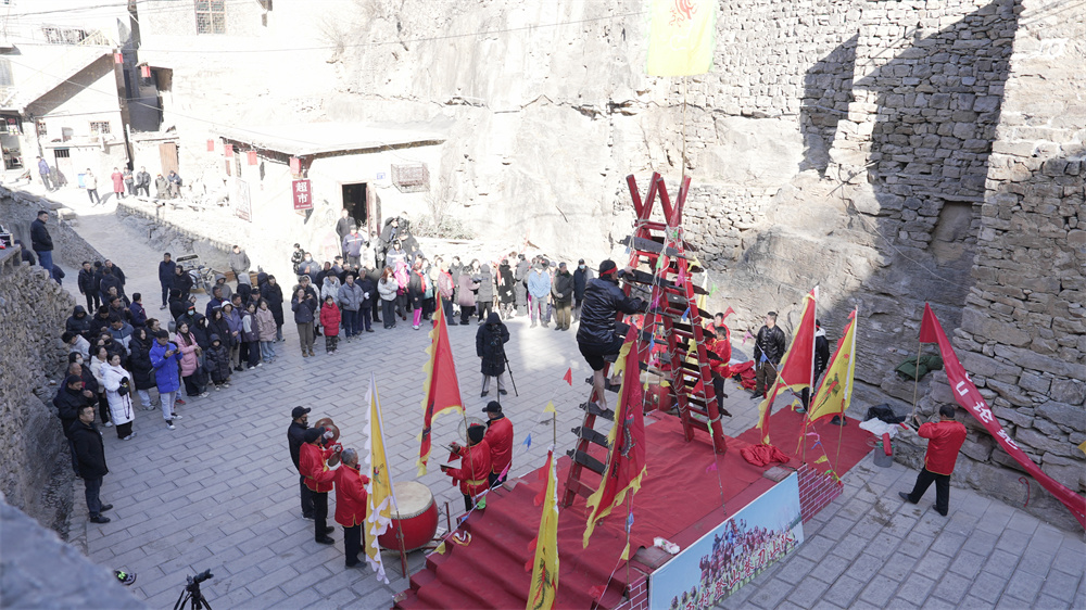当地村民和游客正在观看省级非物质文化遗产代表性项目上刀山表演。杨彦忠摄