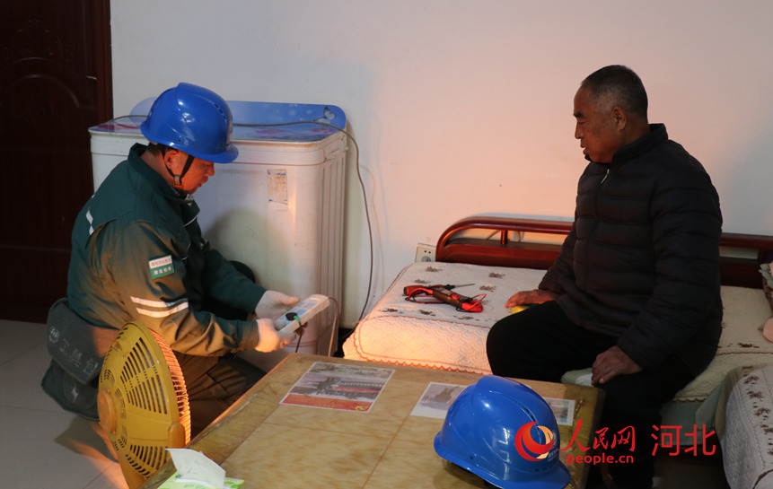 国网赞皇供电公司嶂石岩服务站贾立杰在帮村民检查线路。人民网记者 祝龙超摄