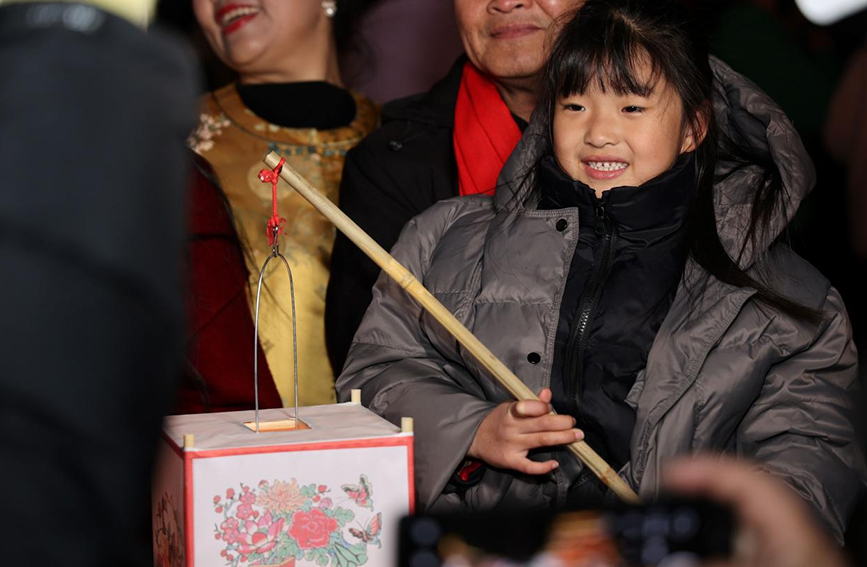 活动现场，女孩手提灯笼感受传统年味。傅新春摄