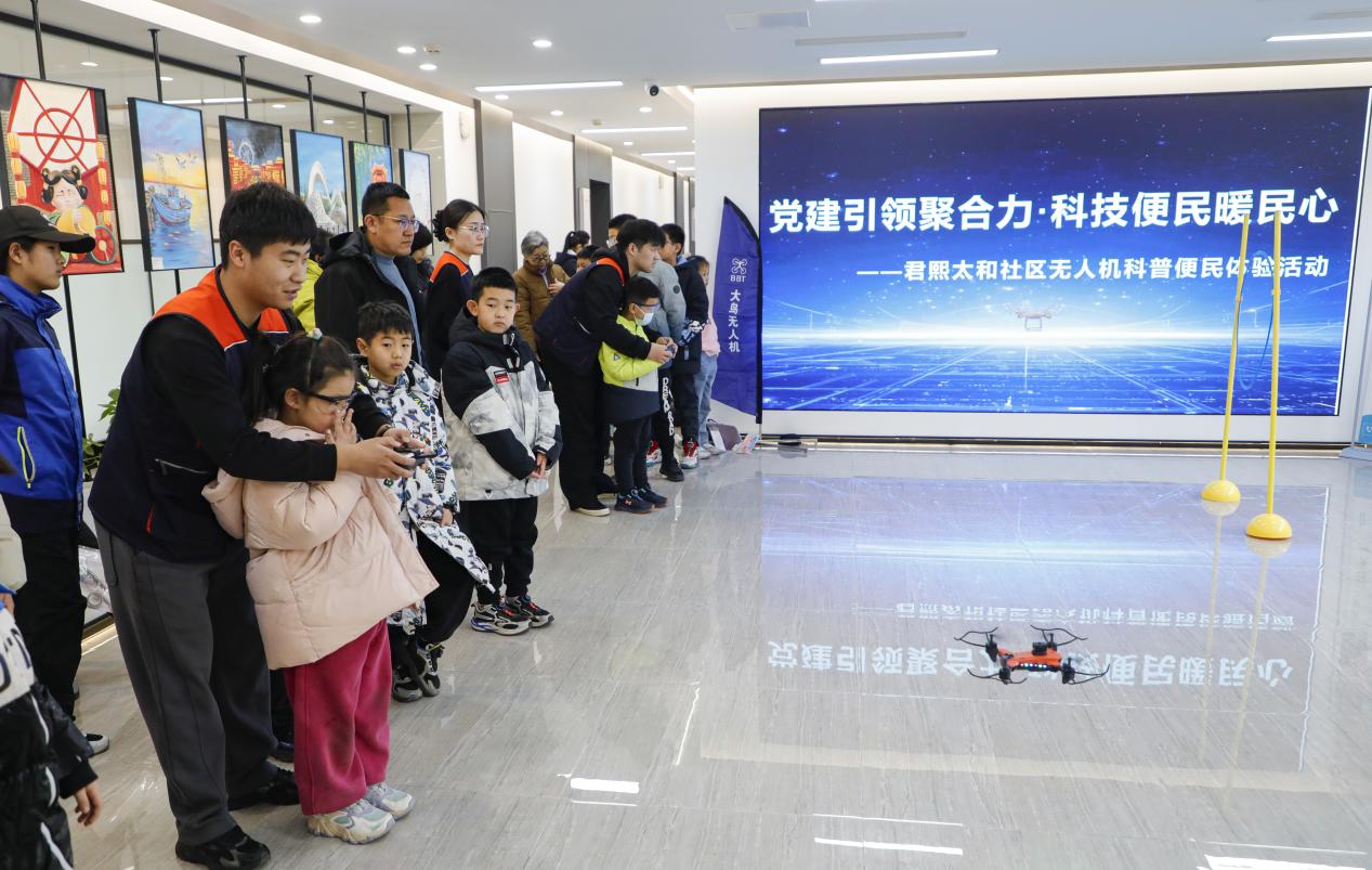 丰南区港岛中心商户大鸟无人机员工向居民演示无人机操作。陈军摄