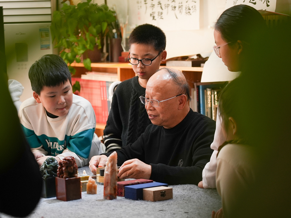 文艺志愿者向孩子们讲解篆刻步骤。刘一明摄