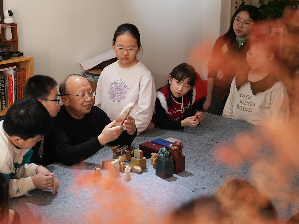孩子们聚精会神地听文艺志愿者讲解篆刻知识。刘一明摄