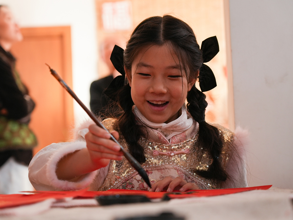 孩子提笔蘸墨,认真临摹书写“福”字。刘一明摄