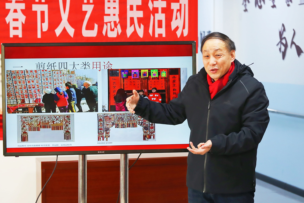 非物質文化遺產代表性傳承人向居民介紹非遺剪紙知識。岑屹攝