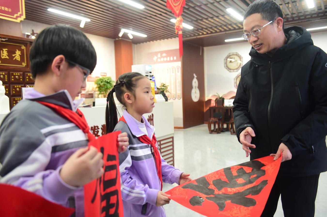 沧州市书法家协会主席贾徽（右一）为小学生讲解“福”字里的年俗。傅新春摄