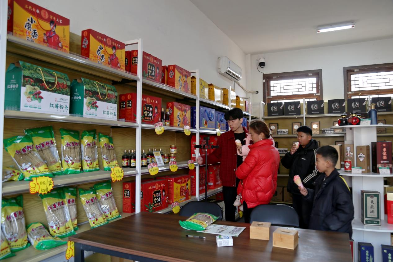 游客在年俗集市上挑选本地特色年货。郭江鹏摄