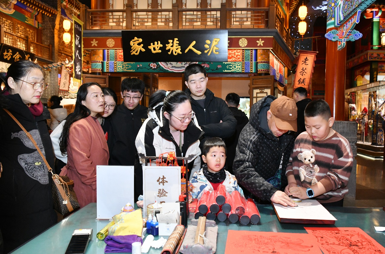 2月19日，游客在位于河北沧州的中国大运河非物质文化遗产展示馆体验制作杨柳青木版年画。苑立伟摄