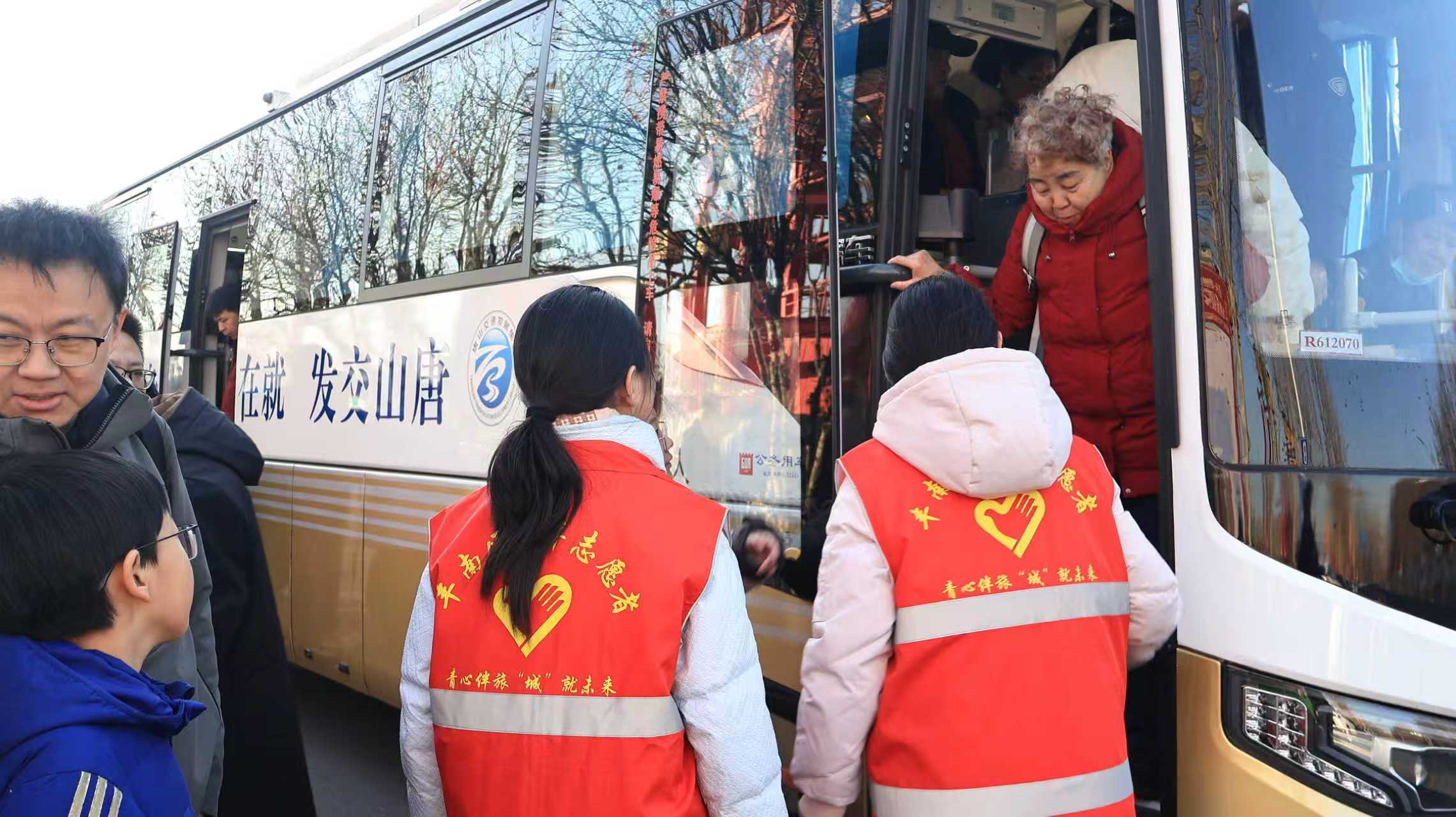 青年志愿者帮助老年乘客下车。左笑萱摄