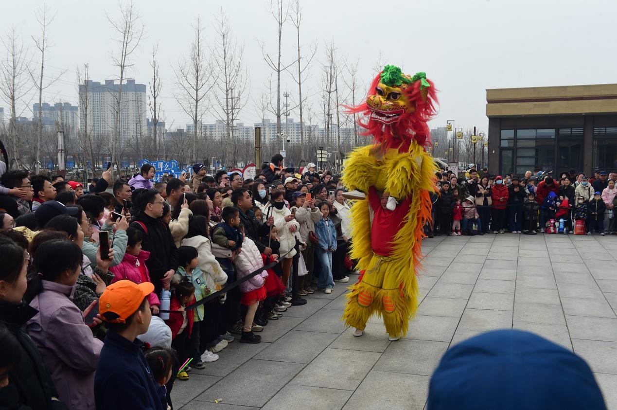 游客在中国大运河非遗展示馆广场观赏舞狮表演。傅新春摄