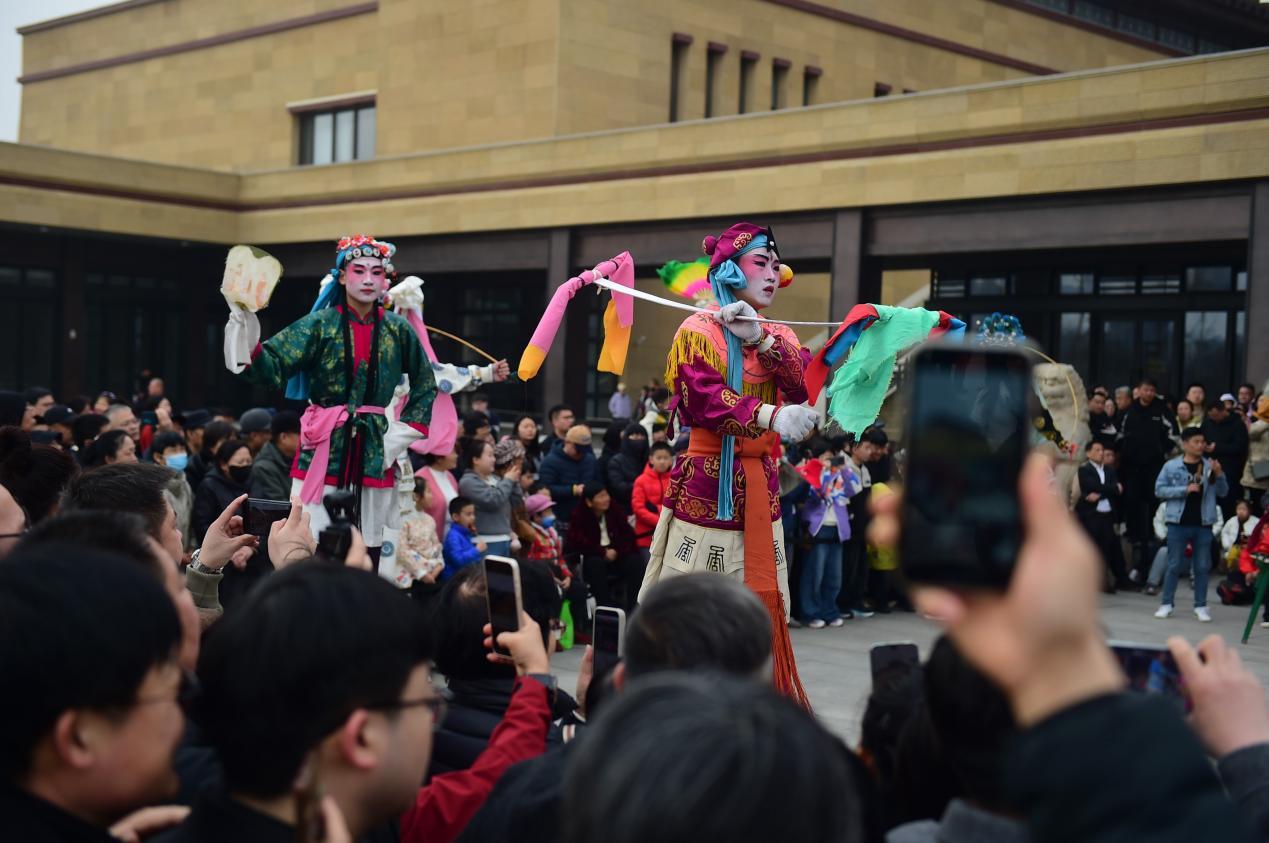 游客在中国大运河非遗展示馆广场观赏高跷表演。傅新春摄
