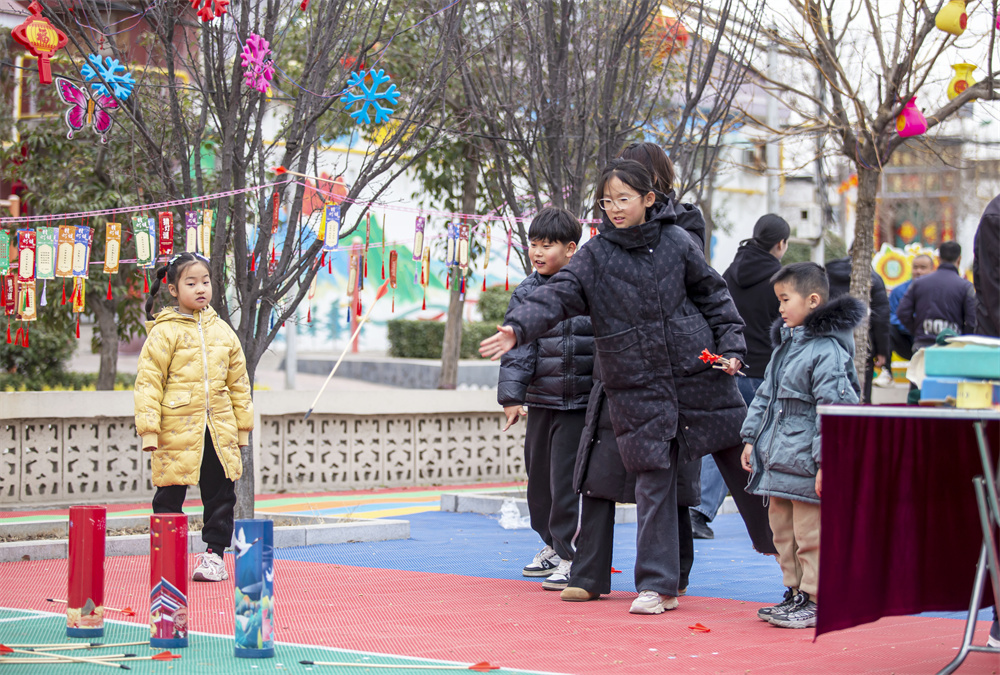 2月23日，河北省邯郸市复兴区二六七二街道东高河村，孩子们在投壶游戏。聂长青摄