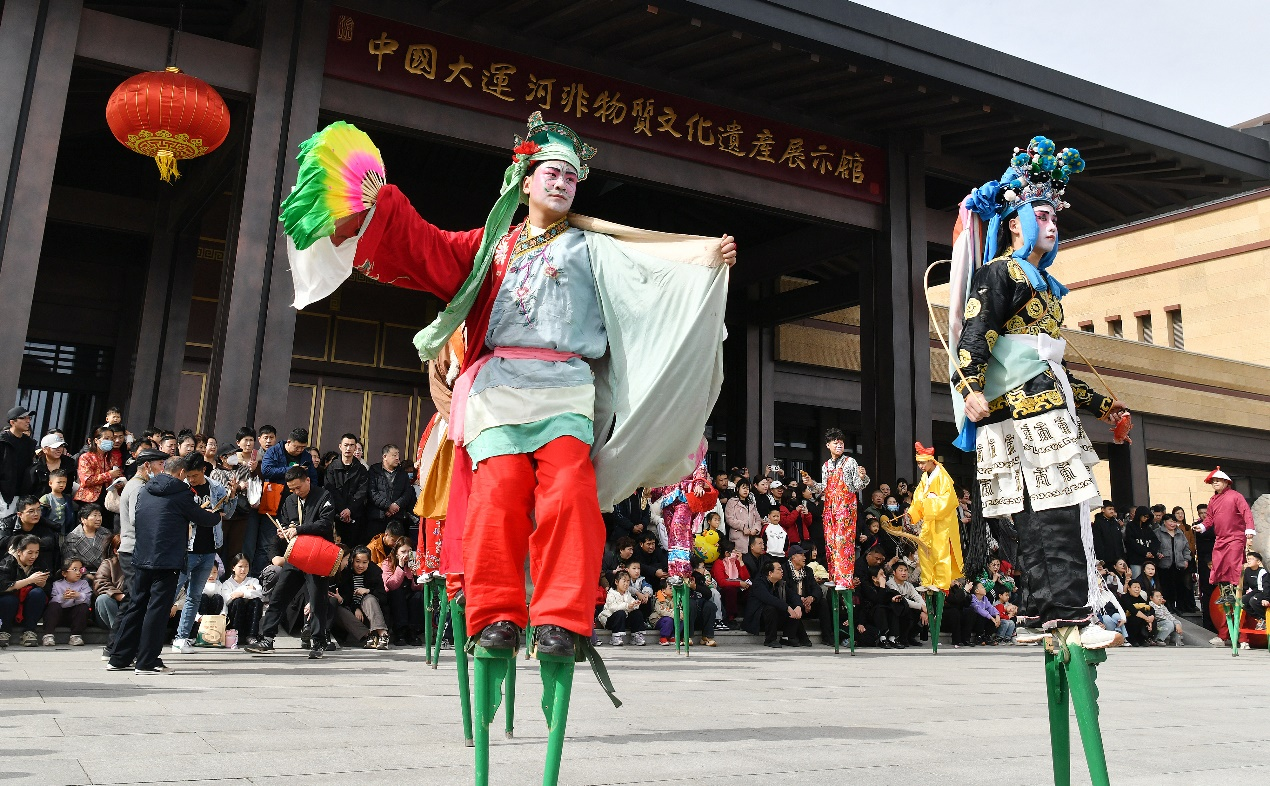 2月21日，民间艺人在位于河北沧州的中国大运河非物质文化遗产展示馆广场为游客表演踩高跷。苑立伟摄