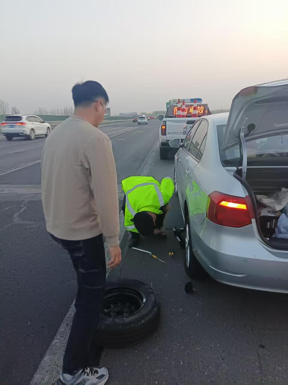 巡查隊員為爆胎車輛更換備胎。河北高速集團供圖