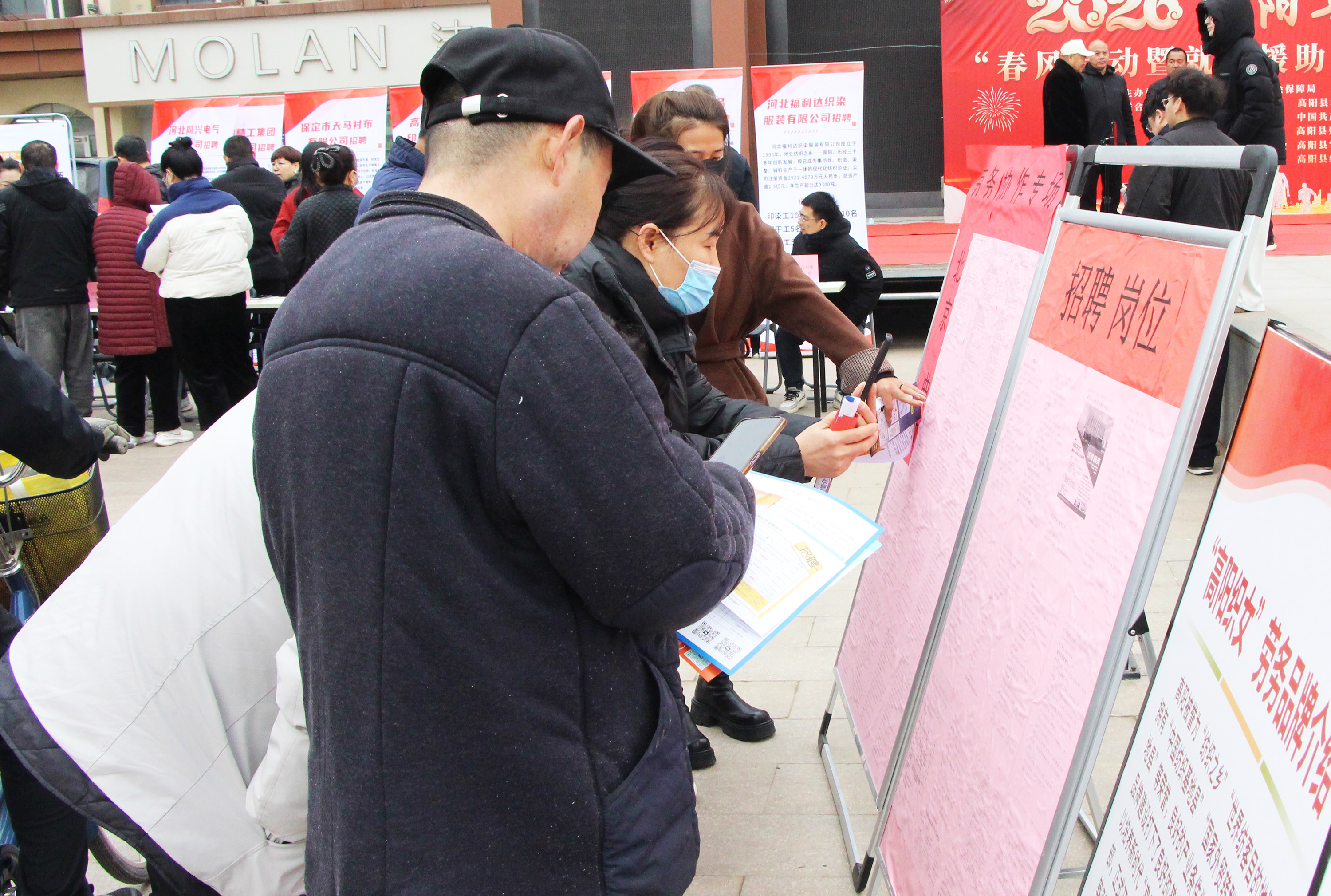 求职者们观看域外岗位招聘展板。杨瀰摄