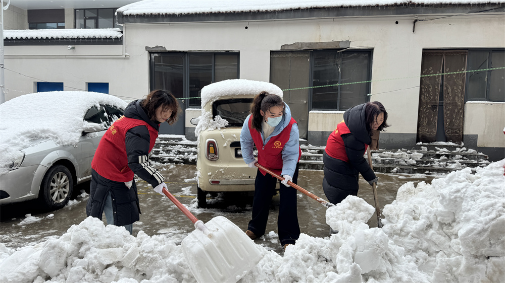 志愿者在居民小区清扫积雪。冯利轩摄