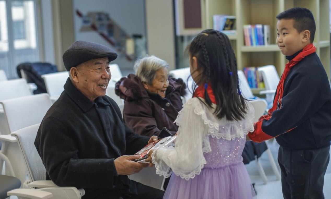 嘉譽瀞湖與錦繡觀邸社區元宵節活動現場，小朋友為長者送元宵。陳軍攝