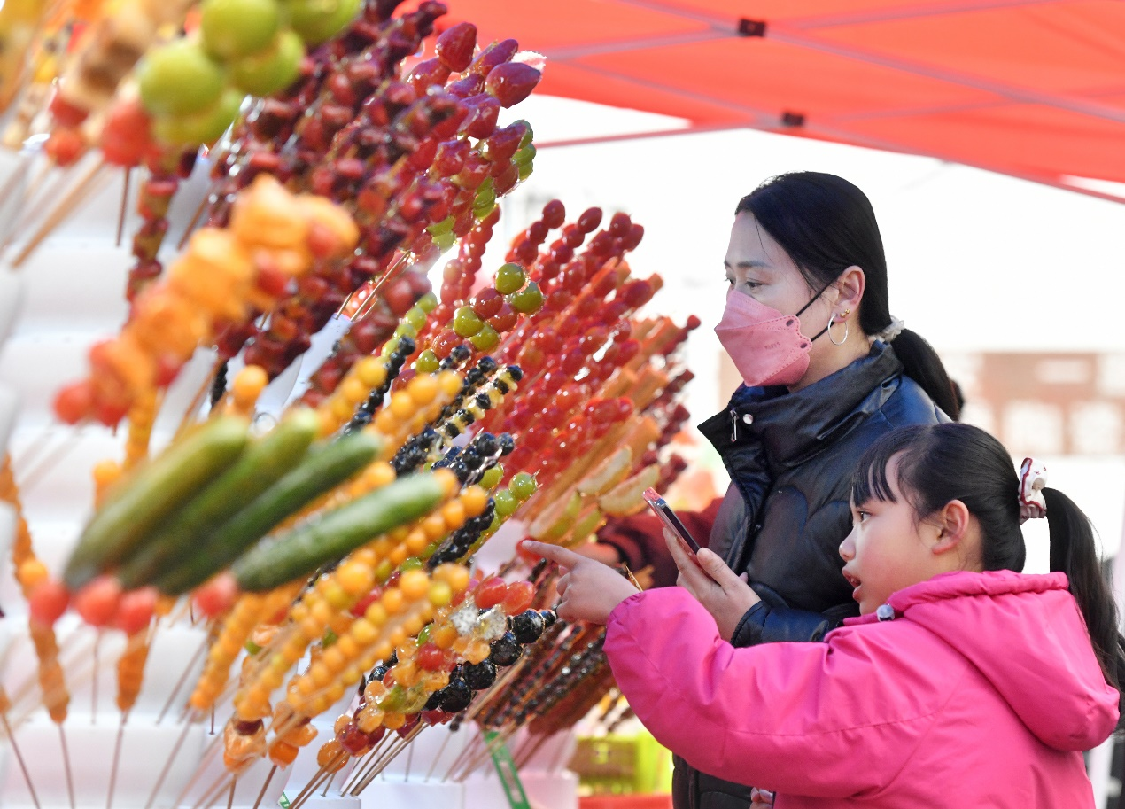 3月1日，游客在任丘市吕公堡镇后李花村“糖墩会”上选购糖墩儿。苑立伟摄