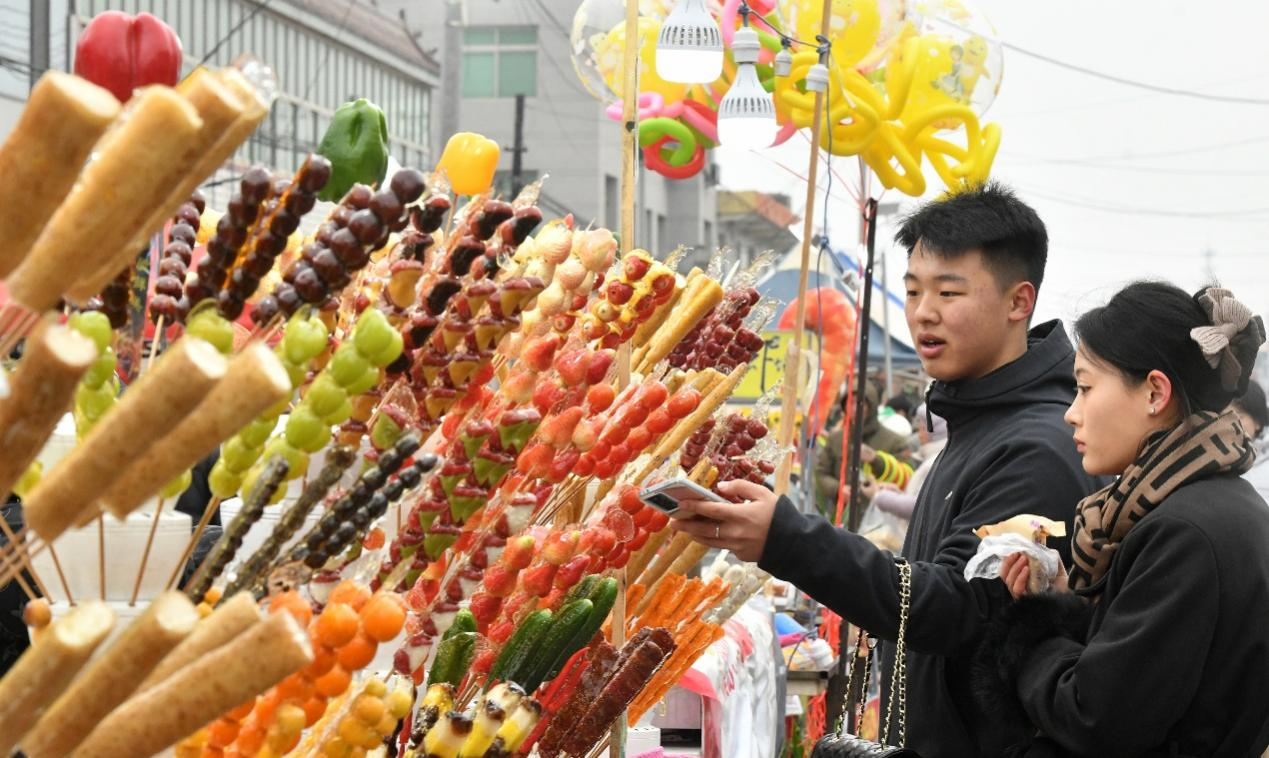 3月1日，游客在任丘市吕公堡镇后李花村“糖墩会”上选购糖墩儿。苑立伟摄