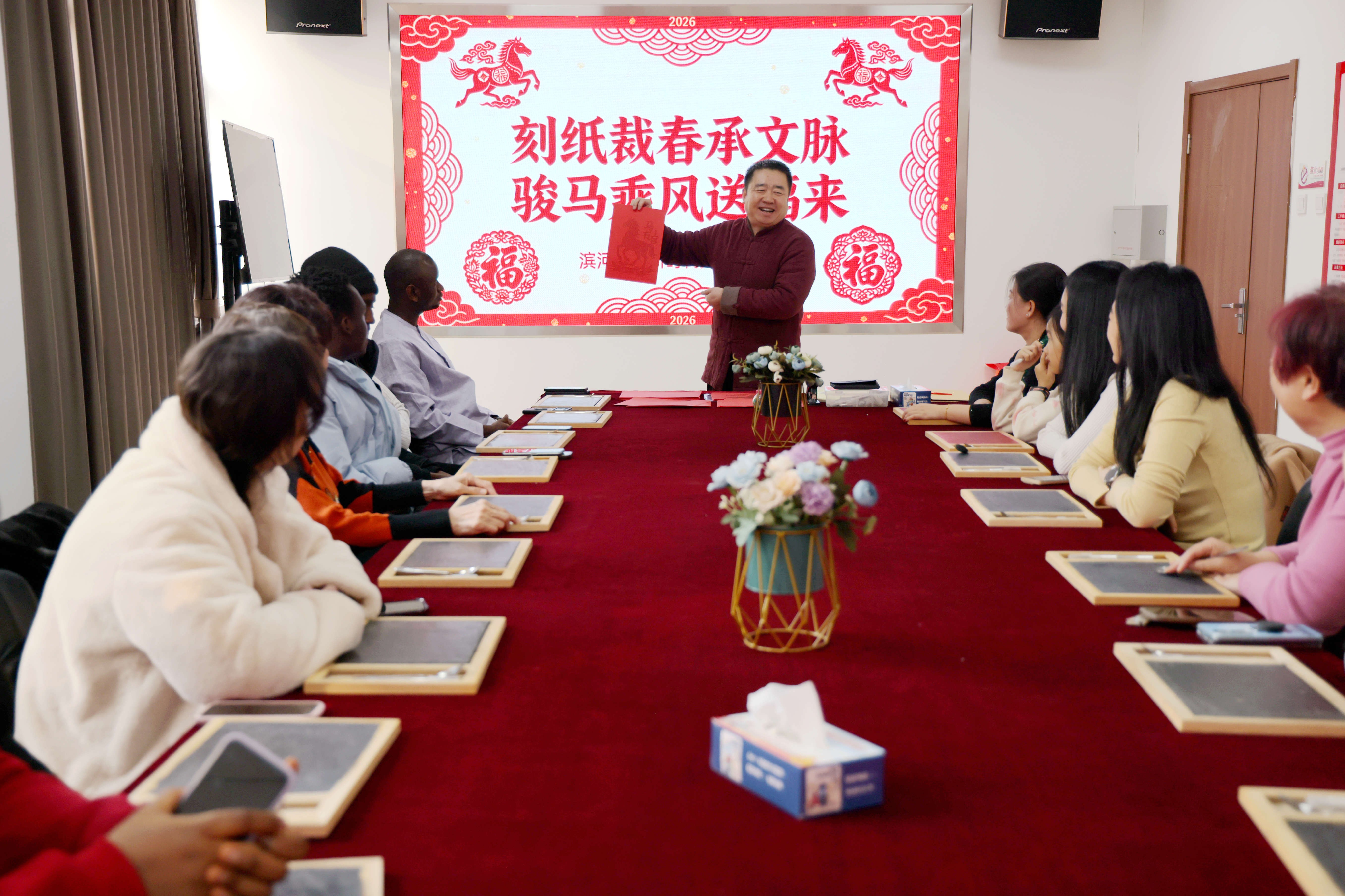 市级非物质文化遗产项目刻纸艺术代表性传承人马振领为留学生及居民讲解刻纸的技巧。王杰摄