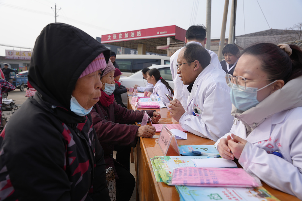 医务人员正在给村民问诊。王雪摄