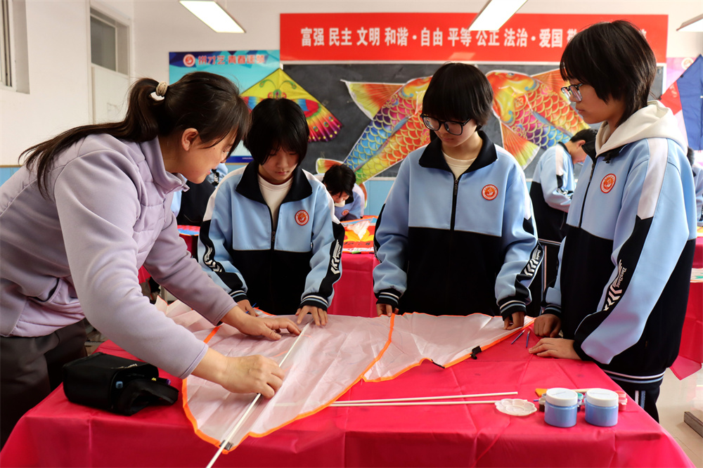 老师在教学生组装风筝。李谦摄