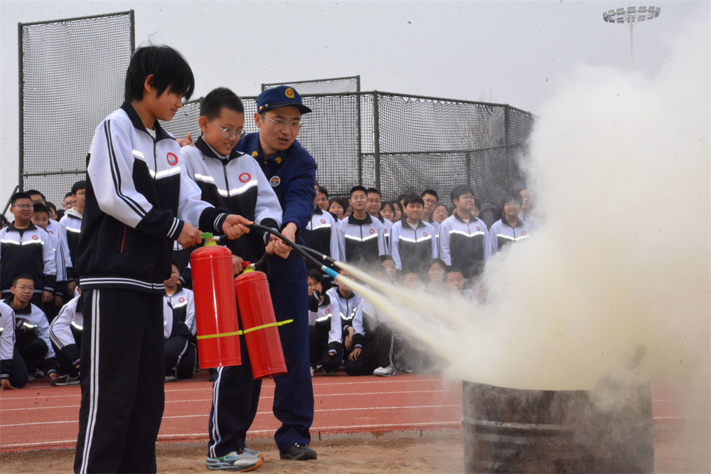 学生们在消防员的指导下进行灭火演练。胡宇婷摄