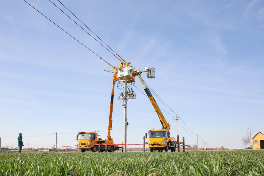 國網高邑縣供電公司帶電作業人員為涉及排灌的10千伏配電線路加裝一二次融合開關。侯旭辰攝