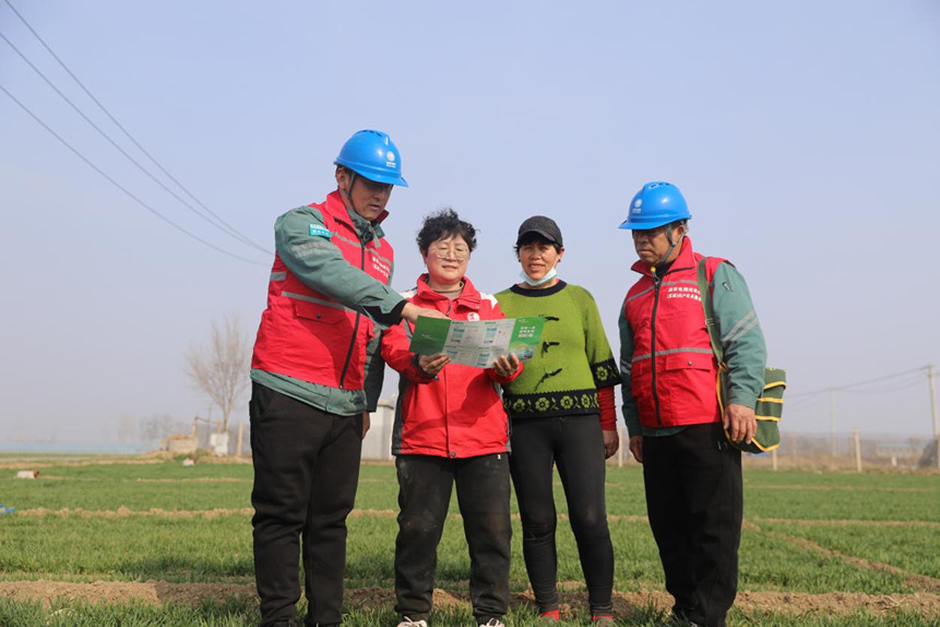 國網石家庄市藁城區供電公司工作人員向農戶講解春灌用電注意事項。趙亞龍攝