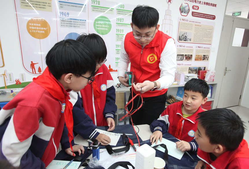 河北送变电公司青年志愿者通过“万用表”向同学们实测演示。刘力睿摄