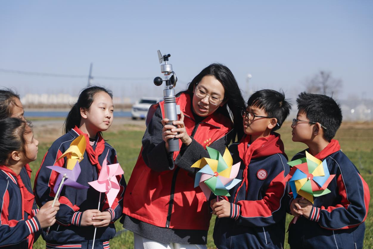 丰南区气象局的工作人员为四神庄小学的学生演示手持气象观测仪。陈军摄