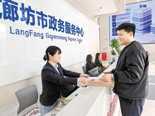 3月26日,在廊坊市政務服務中心“區域通辦”專區,市民(右)正在咨詢“區域通辦”相關事宜。本報記者 劉 杰攝