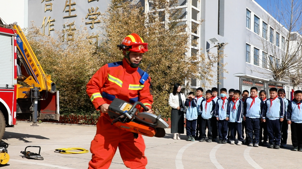 迁安市消防救援大队安全宣传员向学生讲解破拆工具使用方法。王志斌摄
