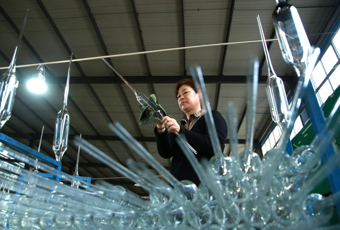 在河北省河间市一家玻璃企业的生产车间内，工人们在忙碌工作。殷实摄