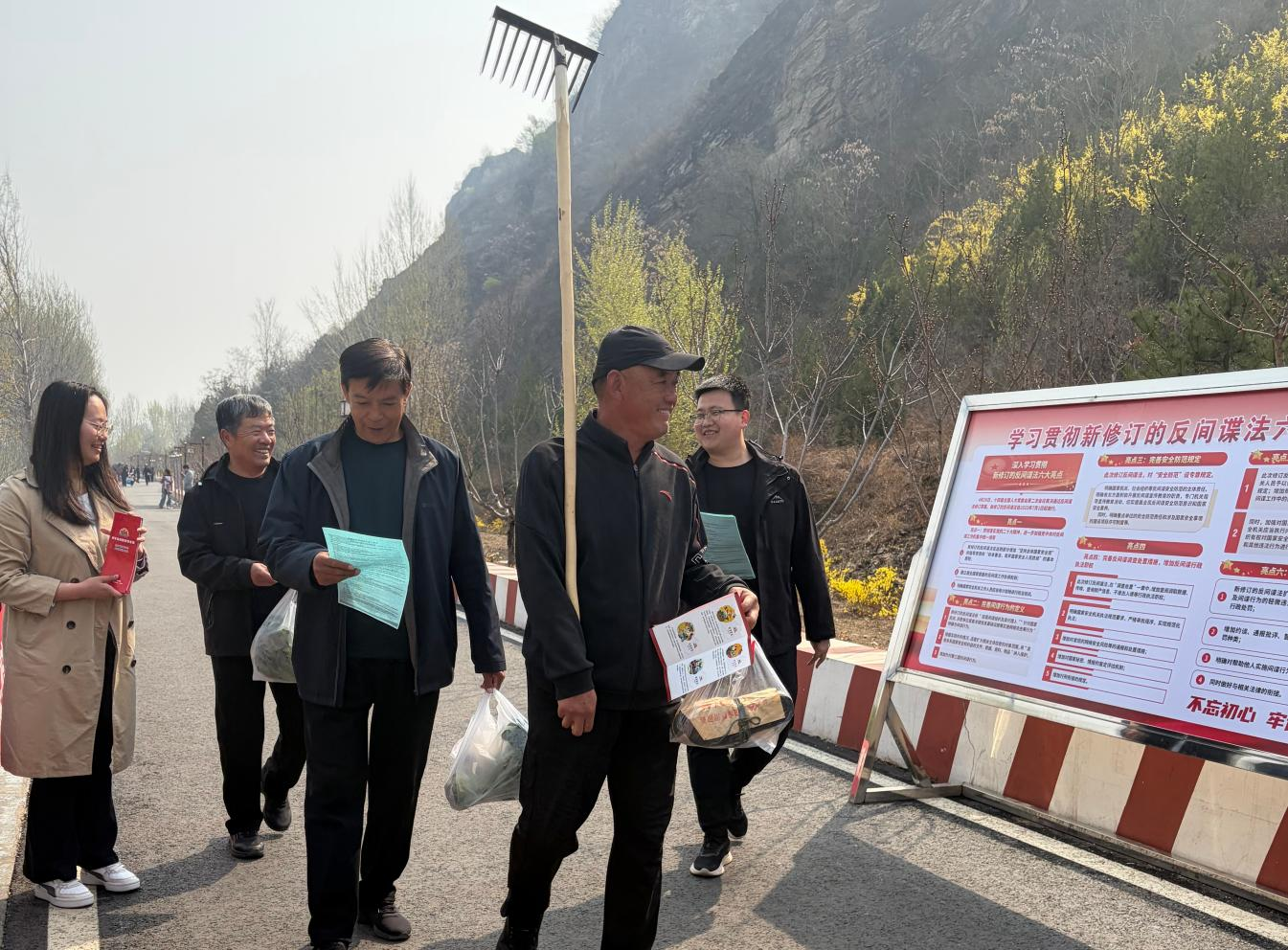 工作人员向过往群众发放宣传资料。张宝摄