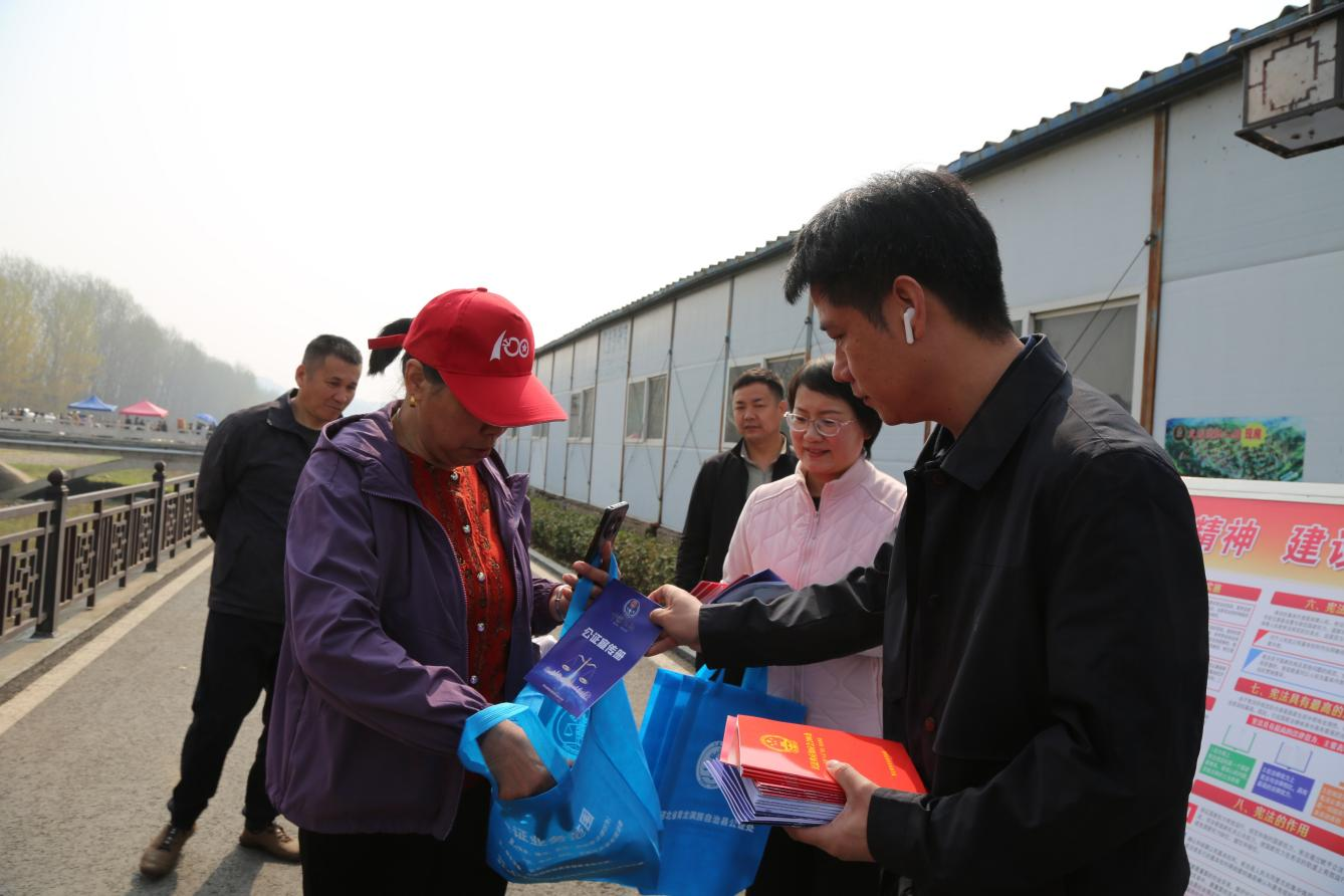 工作人员向过往群众发放宣传资料。张宝摄