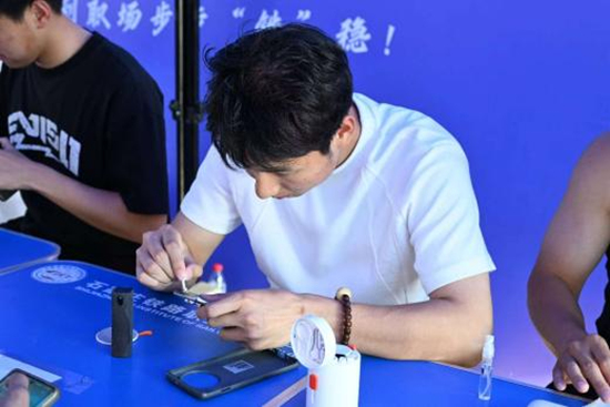 学生为同学手机贴膜志愿服务。石家庄铁路职业技术学院供图