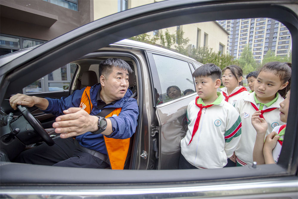 邯郸市红十字中安防减灾服务中心志愿者为孩子们讲解车辆盲区。聂长青摄