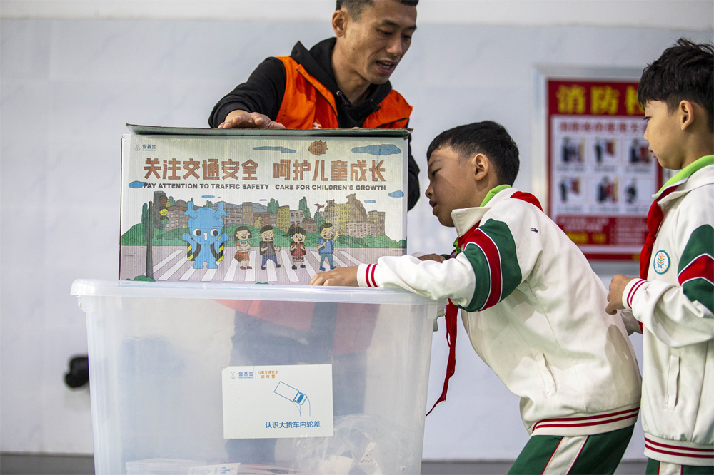 邯郸市红十字中安防减灾服务中心志愿者，引导孩子们观察神奇的盒子，了解光线、距离、反光材质、颜色对行人安全产生的影响。聂长青摄