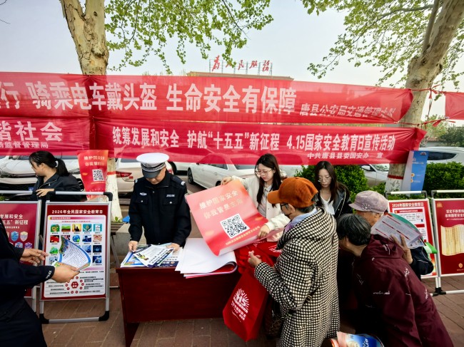 工作人员向群众宣传国家安全官方公众号。赵明乾摄