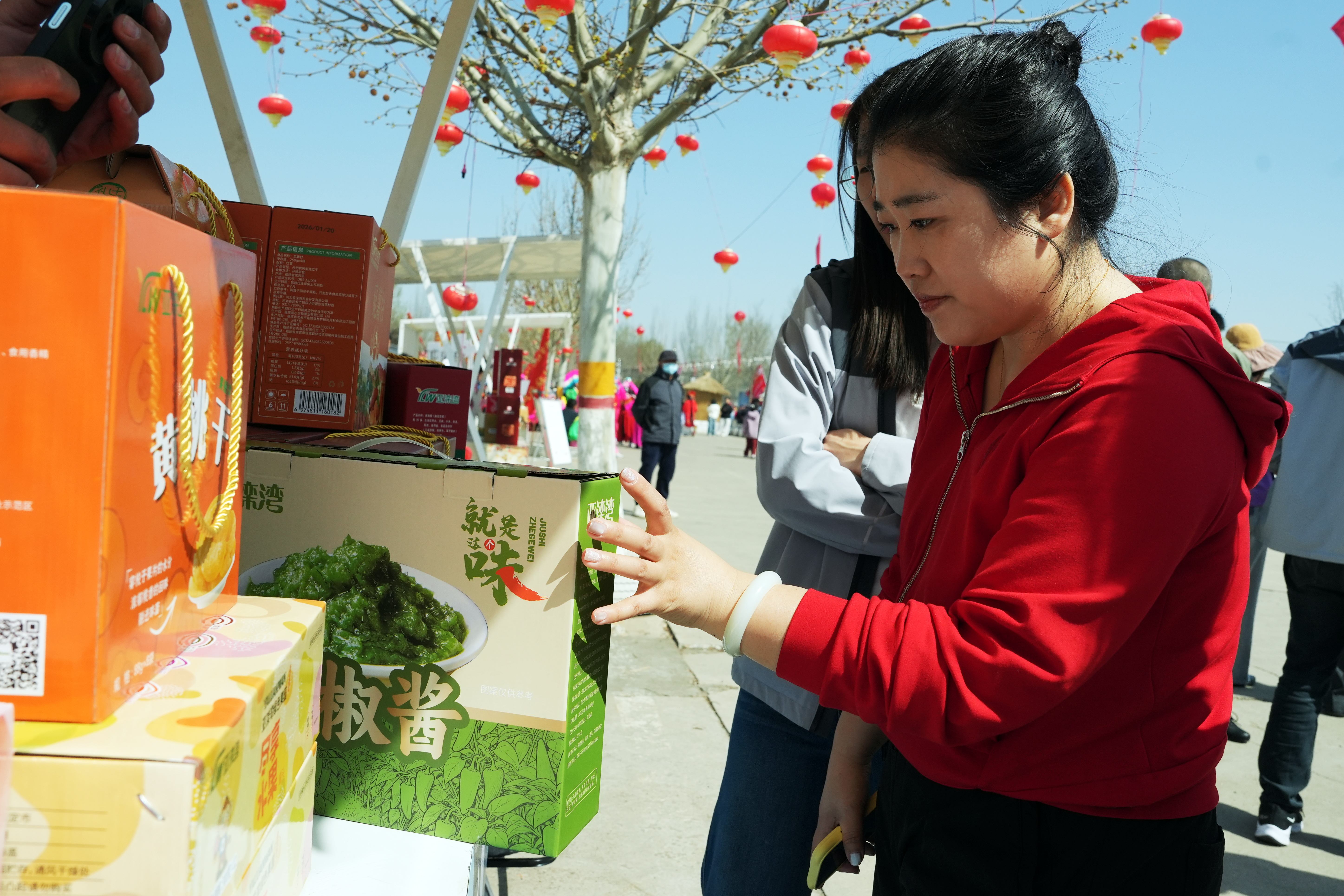 4月11日，在河北亞灤灣桃花節上，游客在選購特色農產品。彭月娟攝