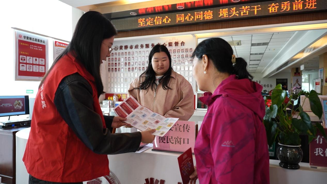 活动现场，志愿者正在为群众讲解国安知识手册。刘冲摄