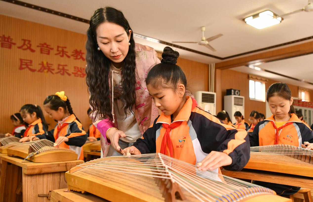 4月3日，在肃宁县融天小学，老师在国乐课上教授学生弹奏古筝。苑立伟摄