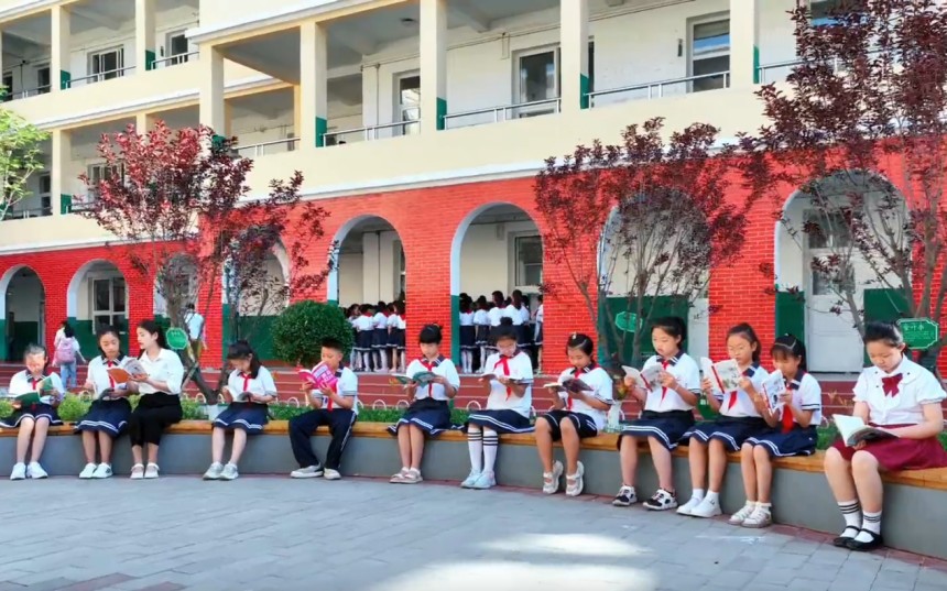 在定州市中心实验小学广场上，老师正在辅导学生们阅读。刘馨忆摄