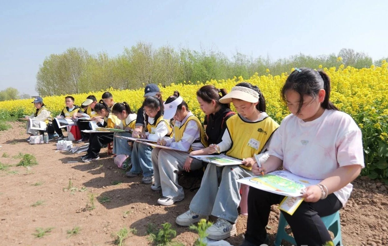 孩子们在油菜花田里写生。王洪胜摄