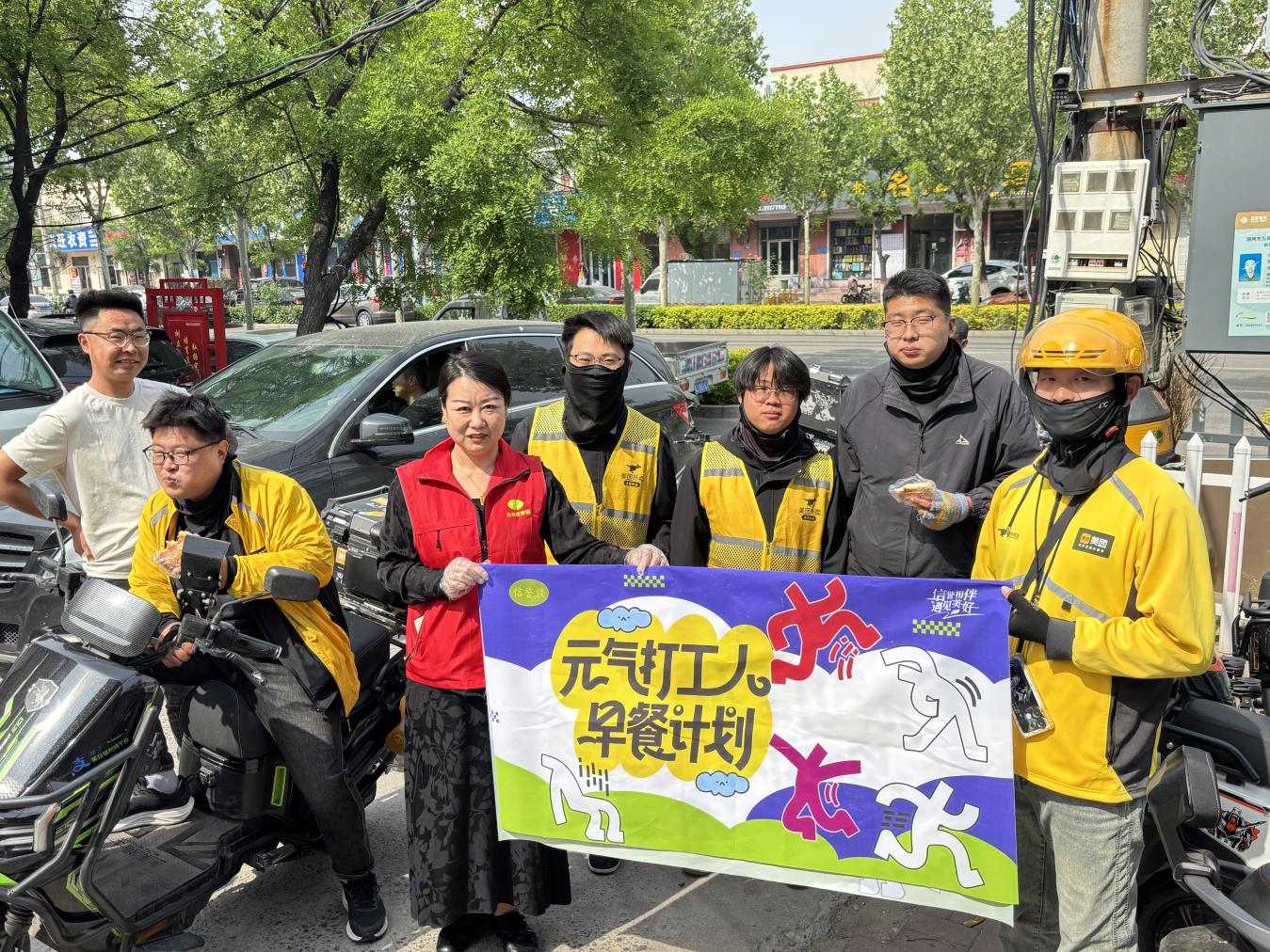 外卖员吃完“暖心早餐”，即将穿行在大街小巷为群众服务。孟悦摄