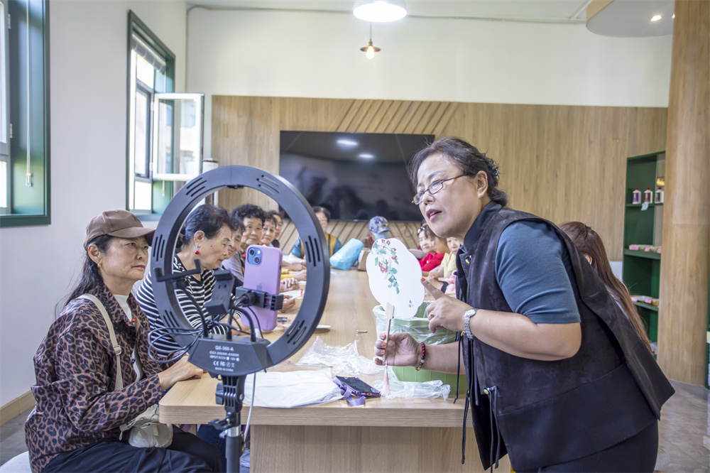专业老师线上线下免费教授居民漆扇制作技巧。聂长青摄