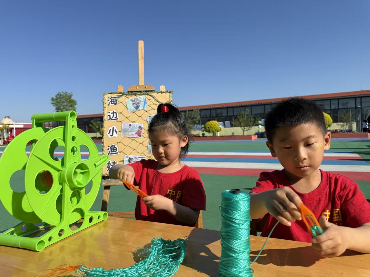 毕家瞿阝幼儿园小朋友正在编织渔网。佟苏美摄