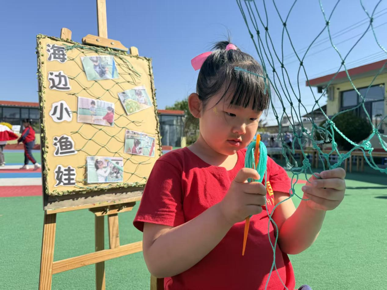 毕家瞿阝幼儿园小朋友正在编织渔网。佟苏美摄