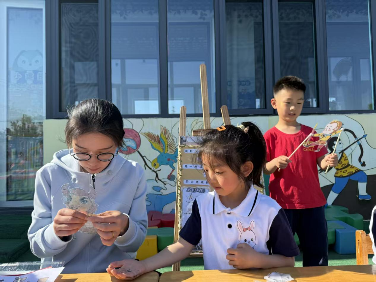 毕家瞿阝幼儿园小朋友正在体验皮影技艺。佟苏美摄