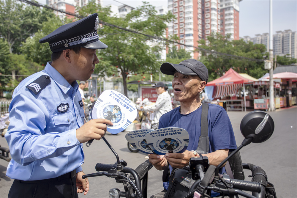 民警向群众发放反诈宣传资料、讲解典型案例。聂长青摄